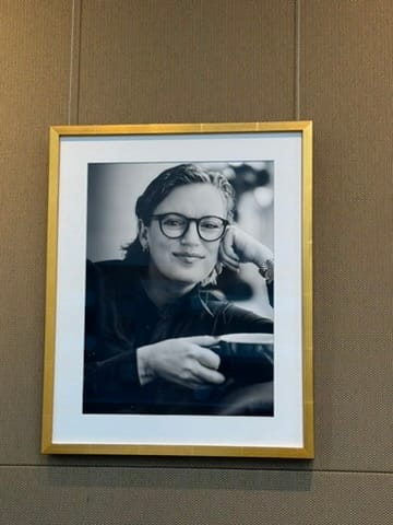 Framed black and white photo hanging on wall, of filmmaker Sarah Polley with a mug