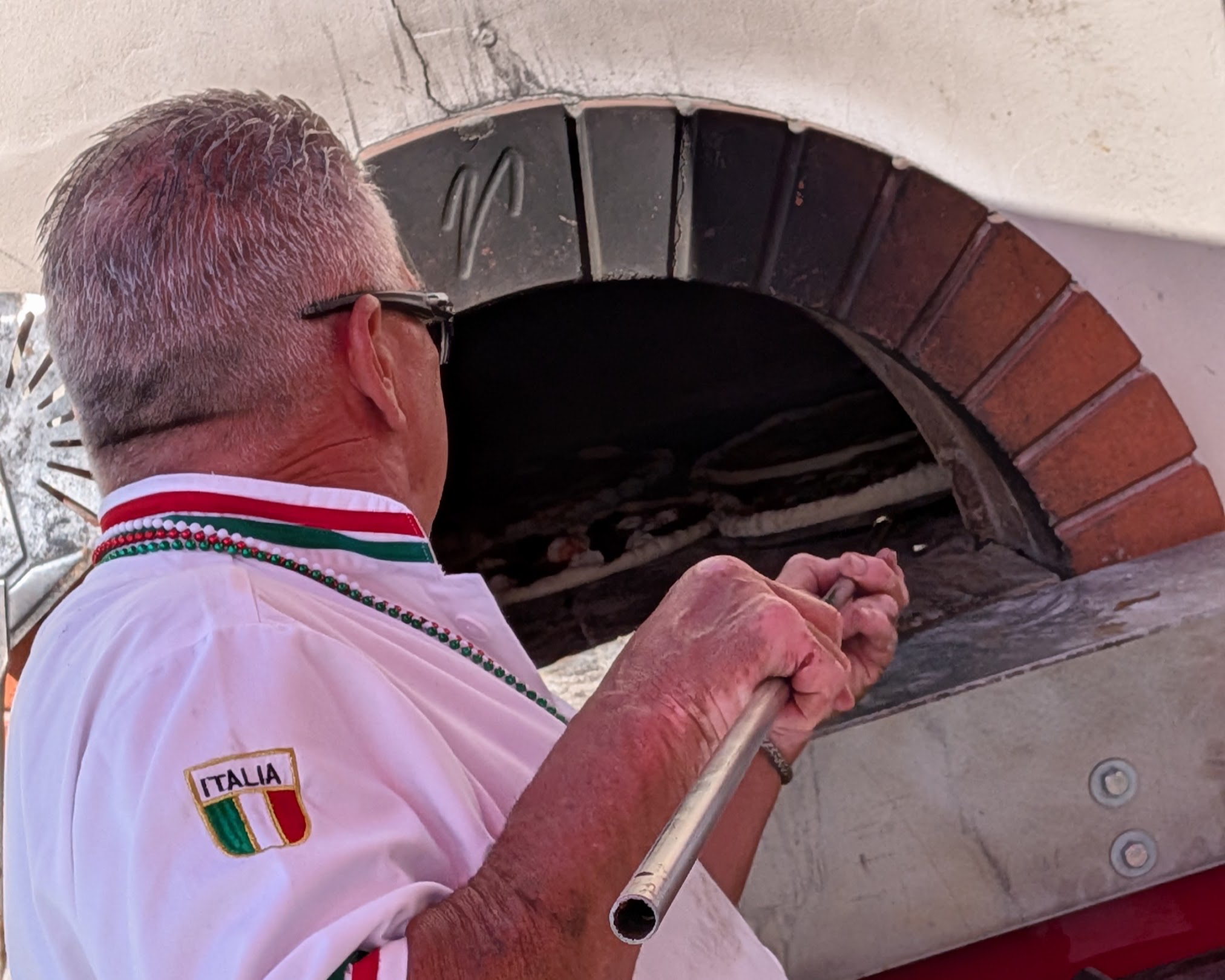 Man putting pizza in pizza oven