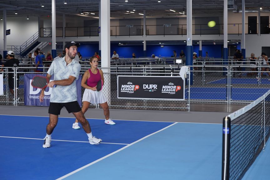 
                                        Two pickleball players playing in a  Minor League Pickleball event
                                    
