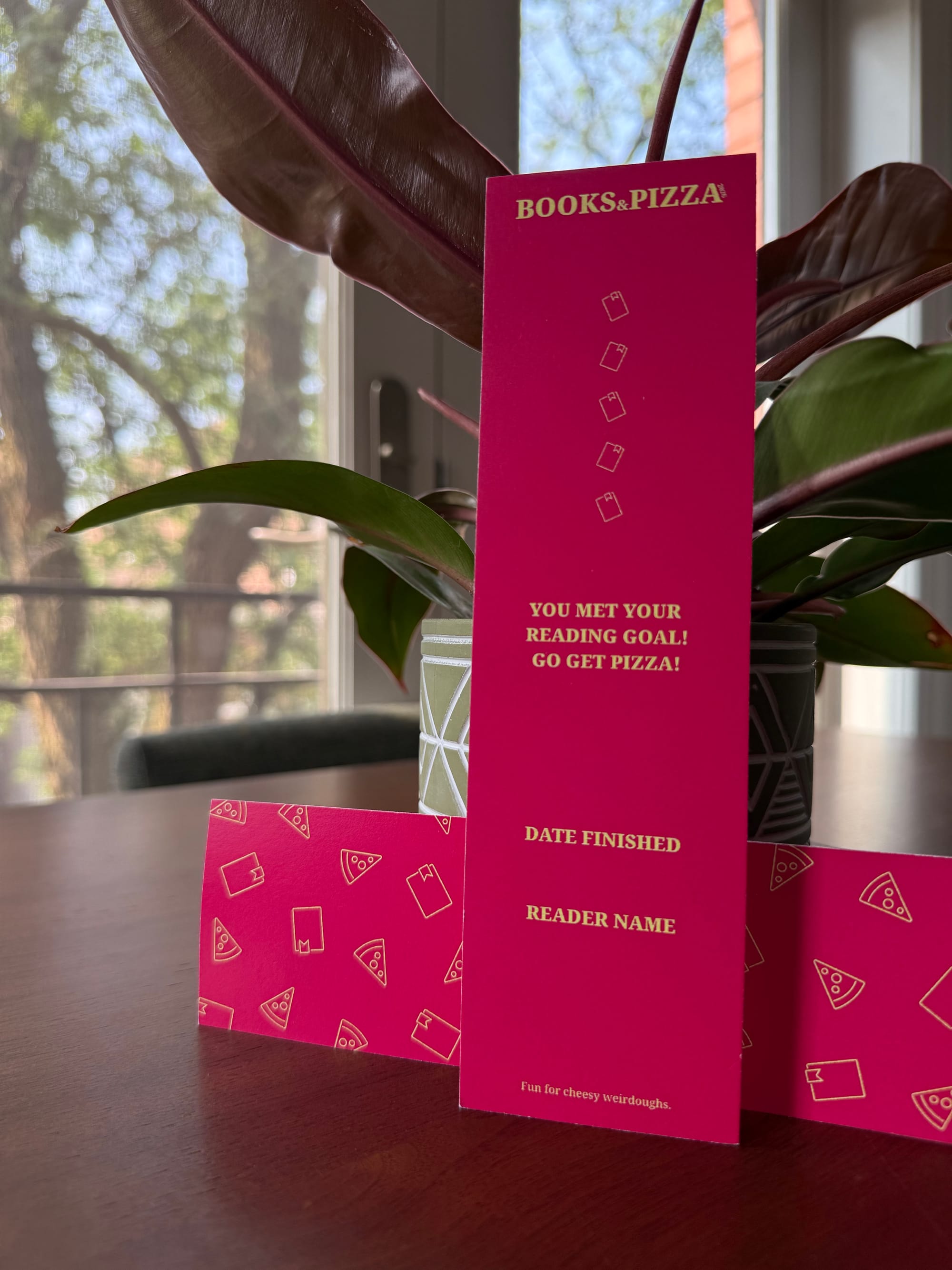 The new bookmark for 2026 leaning against a plant.
