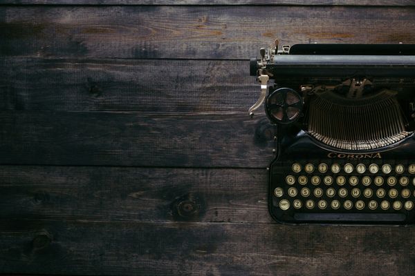 Old typewriter on a wooden table.