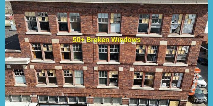 Photo of a building with multiple broken windows.