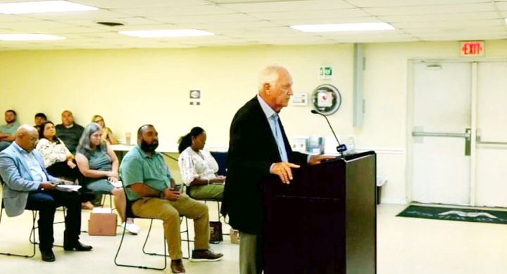 Photo of a man speaking at a podium.