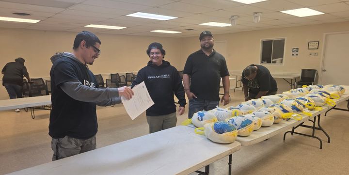 Volunteers are shown distributing frozen turkeys.