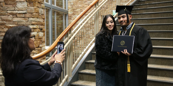 Photo of a recent graduate holding a diploma.