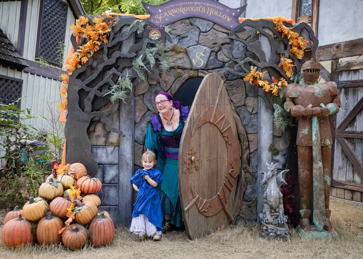 A Renaissance-costumed mother and child open a castle door at Scarborough Hollow in Waxahachie.