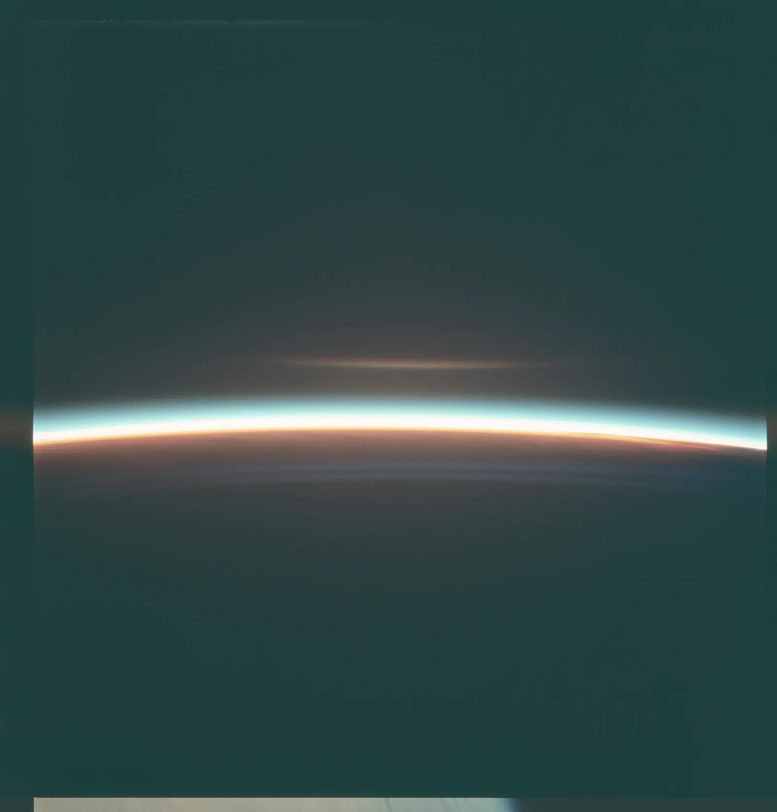 The thin bright edge of Earth's atmosphere against dark space