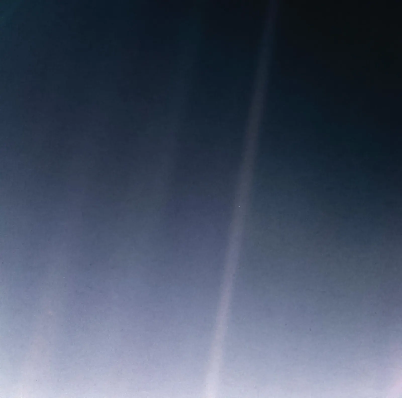 Pale beam of light across a dark blue night sky