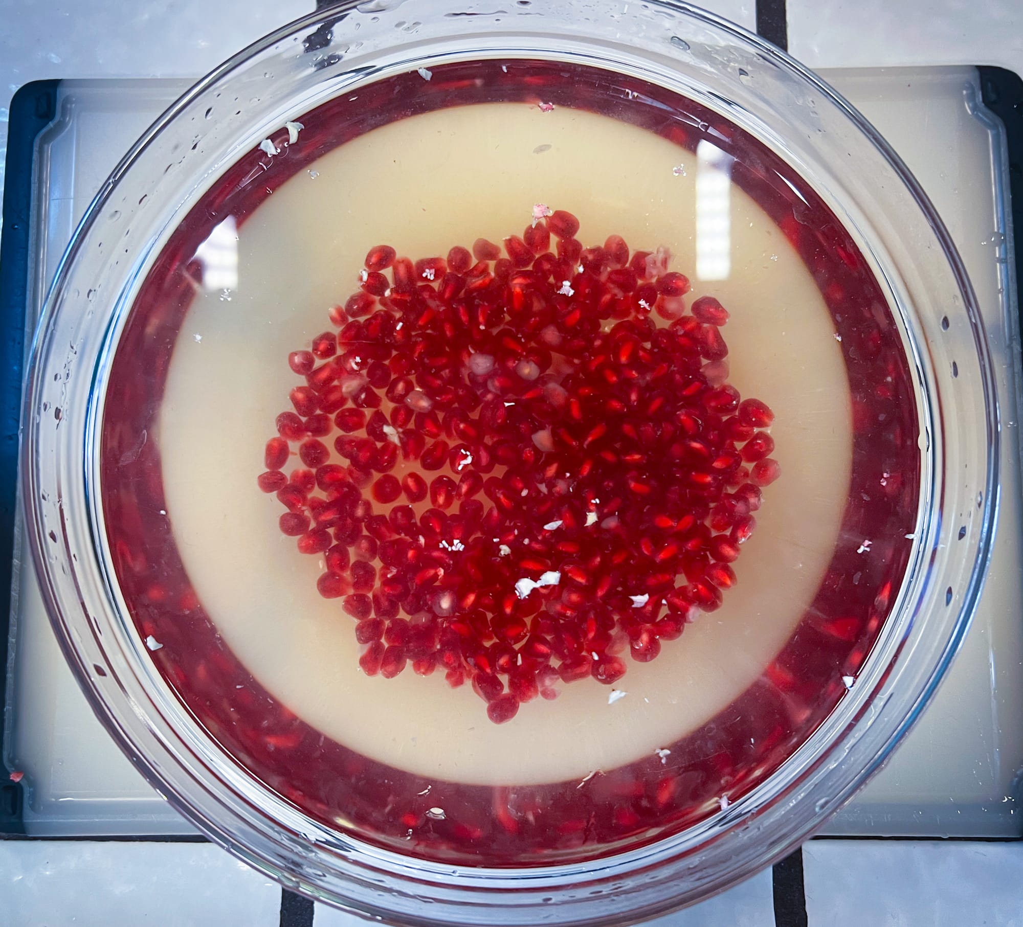Top view of the glass bowl. The big hunks of rind and membrane have been removed, now there are only a very small amount of teensy bits of white floating at the top.