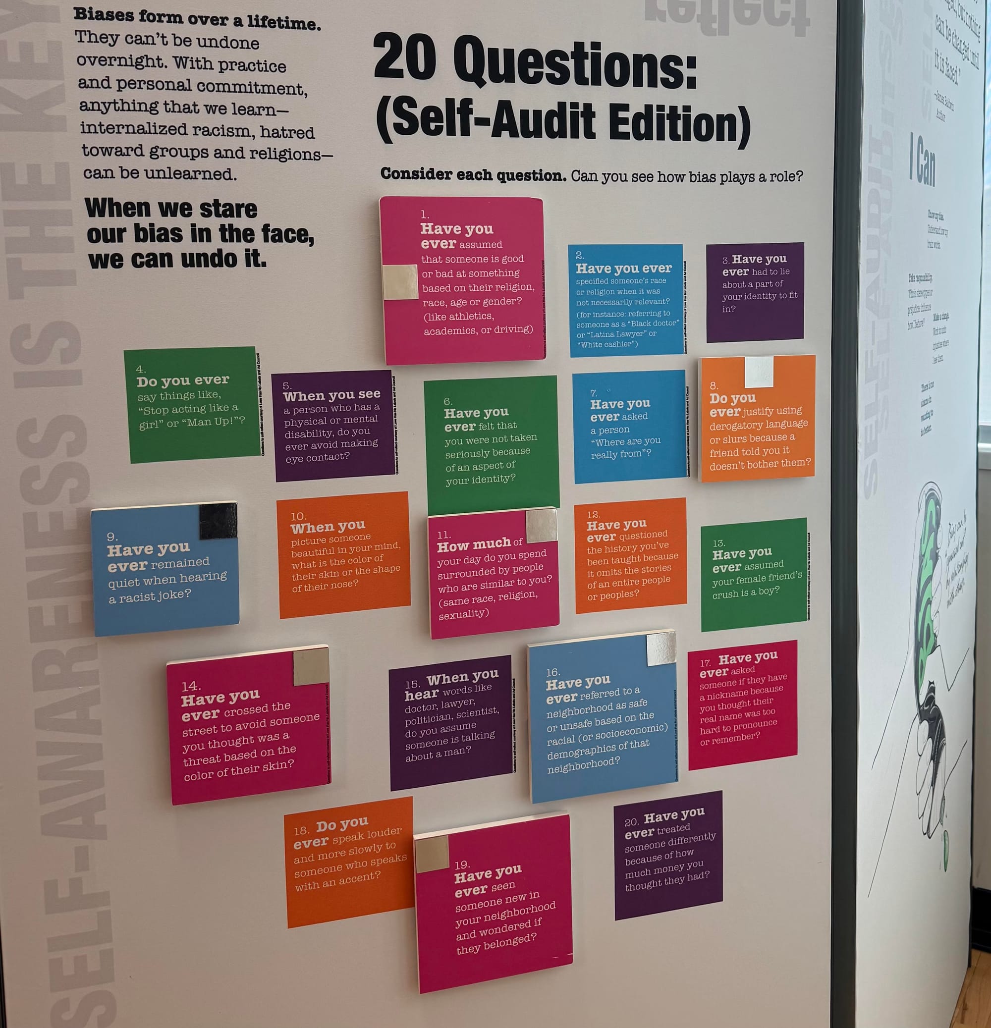 Cards on a poster ask questions such as "Have you ever had to lie about a part of your identity to fit in."