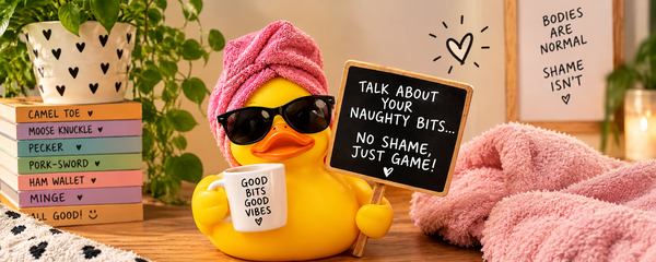 A playful yellow rubber duck wearing sunglasses and a pink towel turban holds a mug reading “Good Bits Good Vibes” and a sign saying “Talk About Your Naughty Bits… No Shame, Just Game!” 