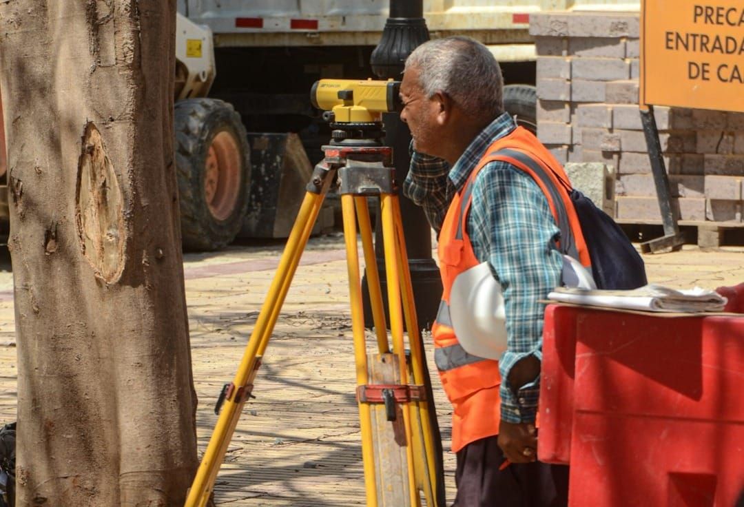 Skilled trades team reviews project details on a rugged tablet, demonstrating efficient digital workforce management on a busy construction site.