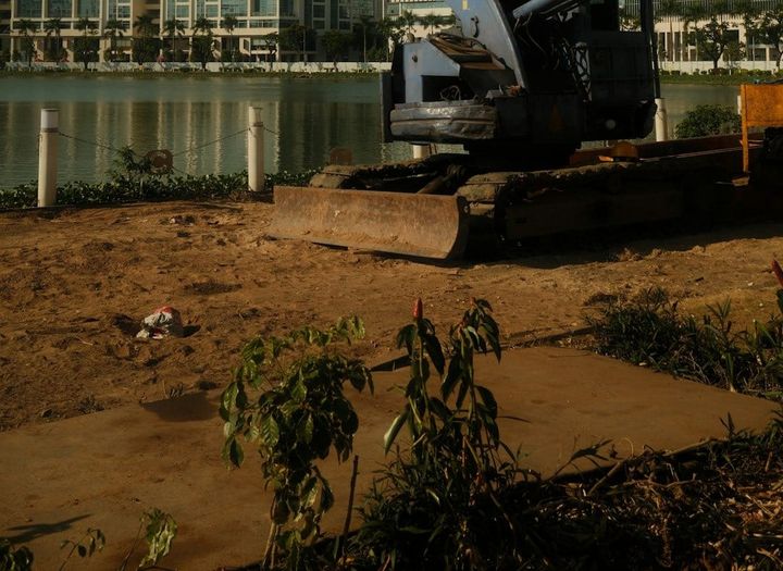 Skilled construction workers operate heavy equipment on a coastal protection project, illustrating large-scale infrastructure development.