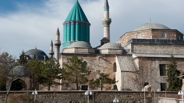 The Mevlana Museum in Konya, the former lodge and tomb of Jalāl al-Dīn Rūmī, with its fluted turquoise dome, seen from the park