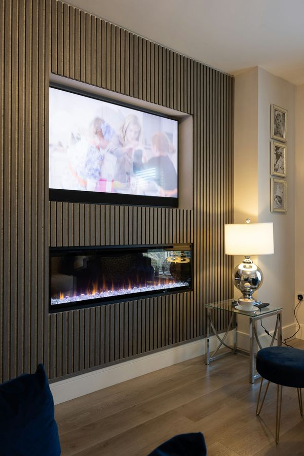 Flat-screen TV mounted above a fireplace in a modern living room with a clean wall and no visible cords