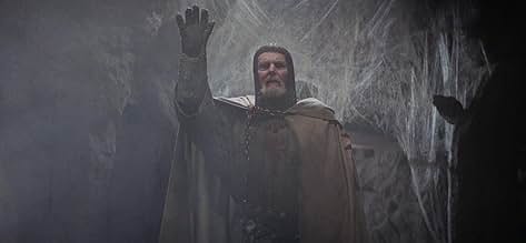 screen shot of old knight standing among spider webs, waving.