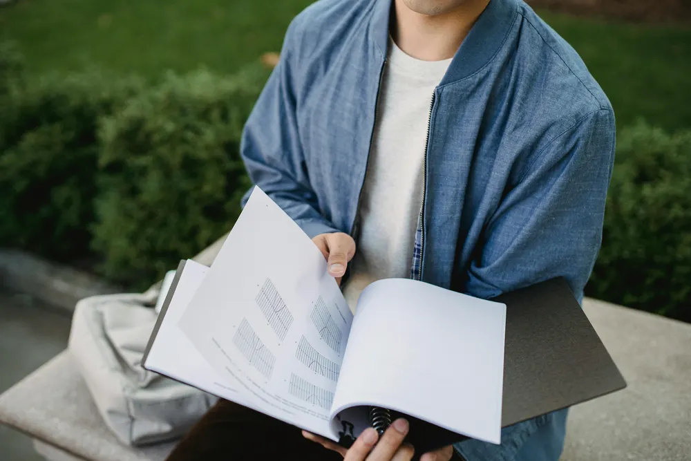 student holding a document - Personal Statement for College