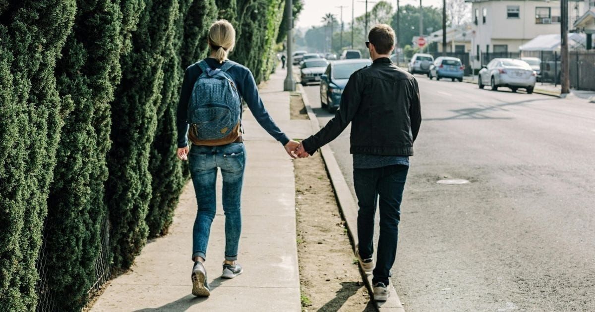 Couple walking together holding hands in their neighborhood