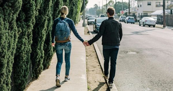 Couple walking together holding hands in their neighborhood