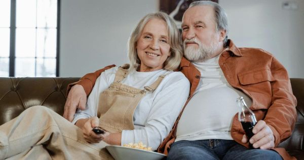 Older couple relaxing together on couch smiling warmly