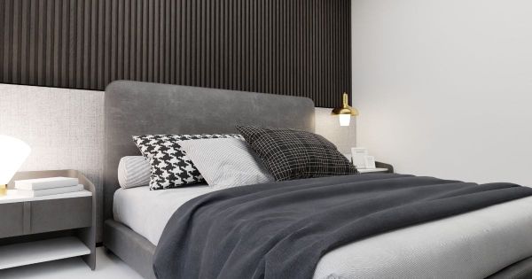 Charcoal throw blanket draped at the foot of a modern bed