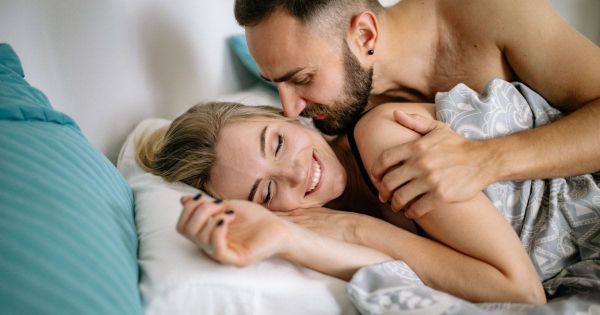 Couple laughing and embracing closely in bed