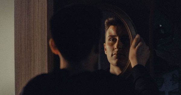 Man looking closely at his reflection in a mirror