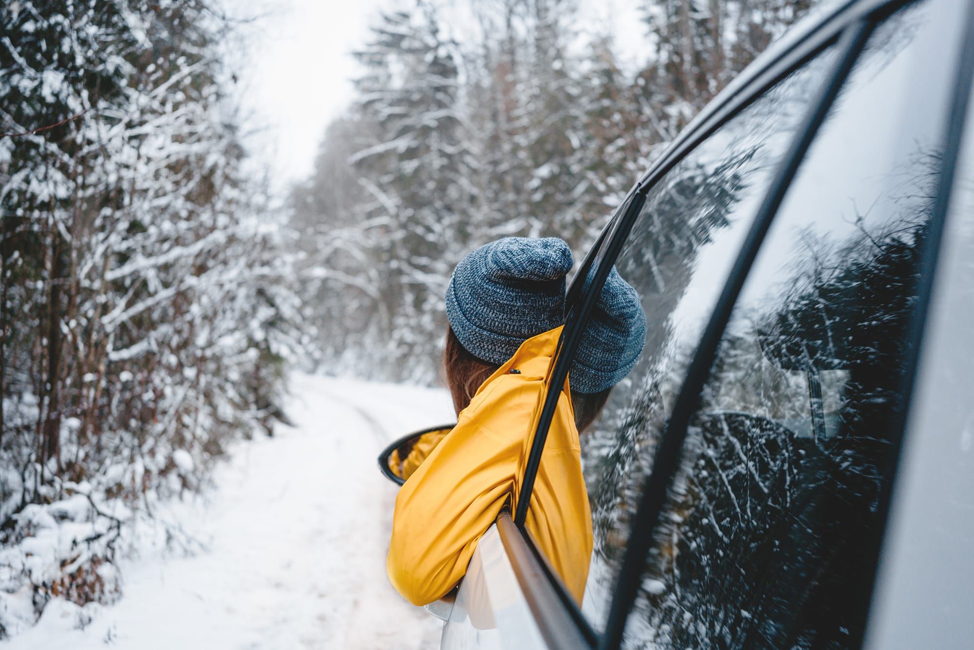 Woman dealing with holiday stress, looking out car into the snow