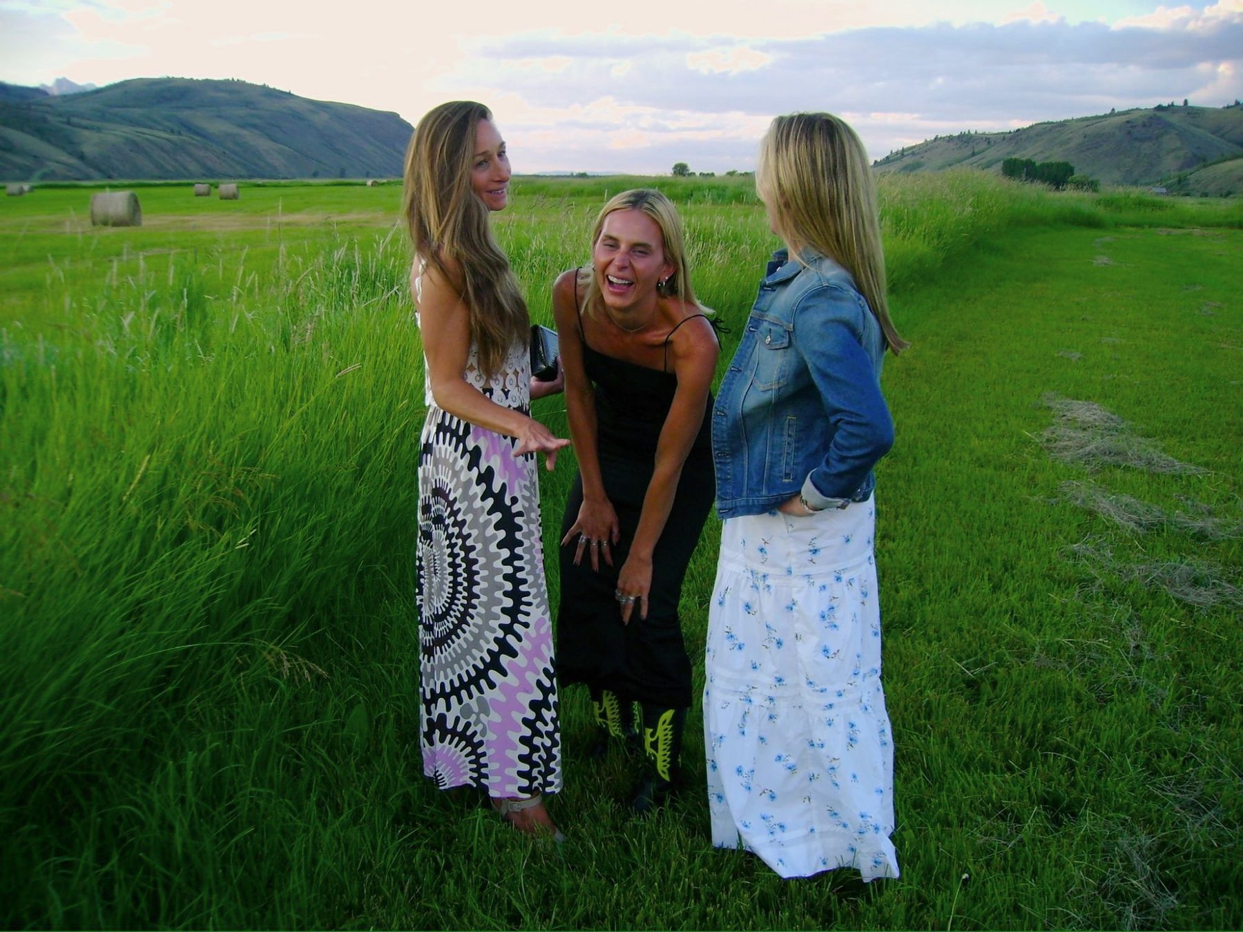 From Kara Hobby’s Wilson Mom summer: three women laughing in a green hayfield