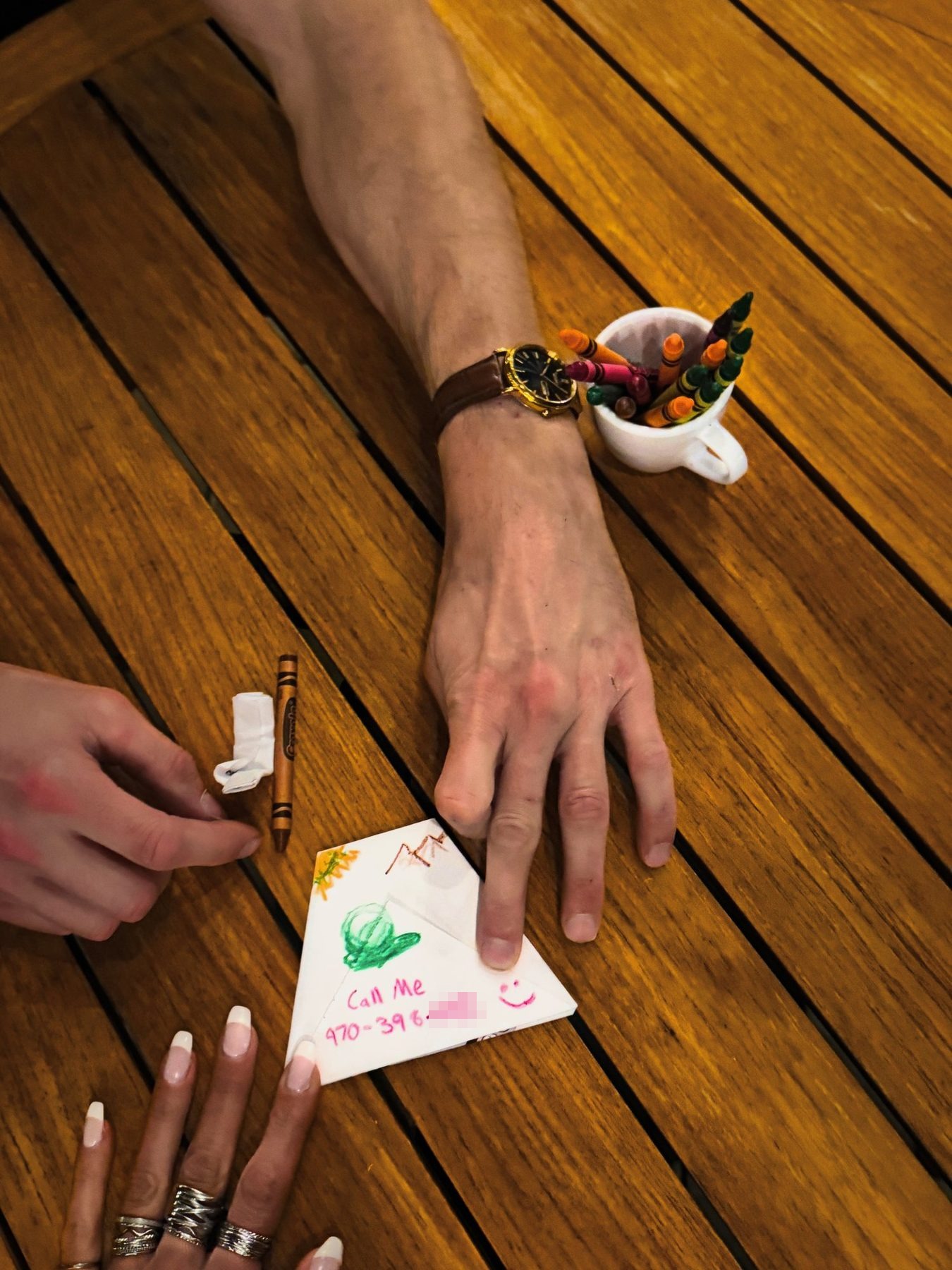 From Kara Hobby’s Wilson Mom summer: hands on a teak table beside a Call Me napkin