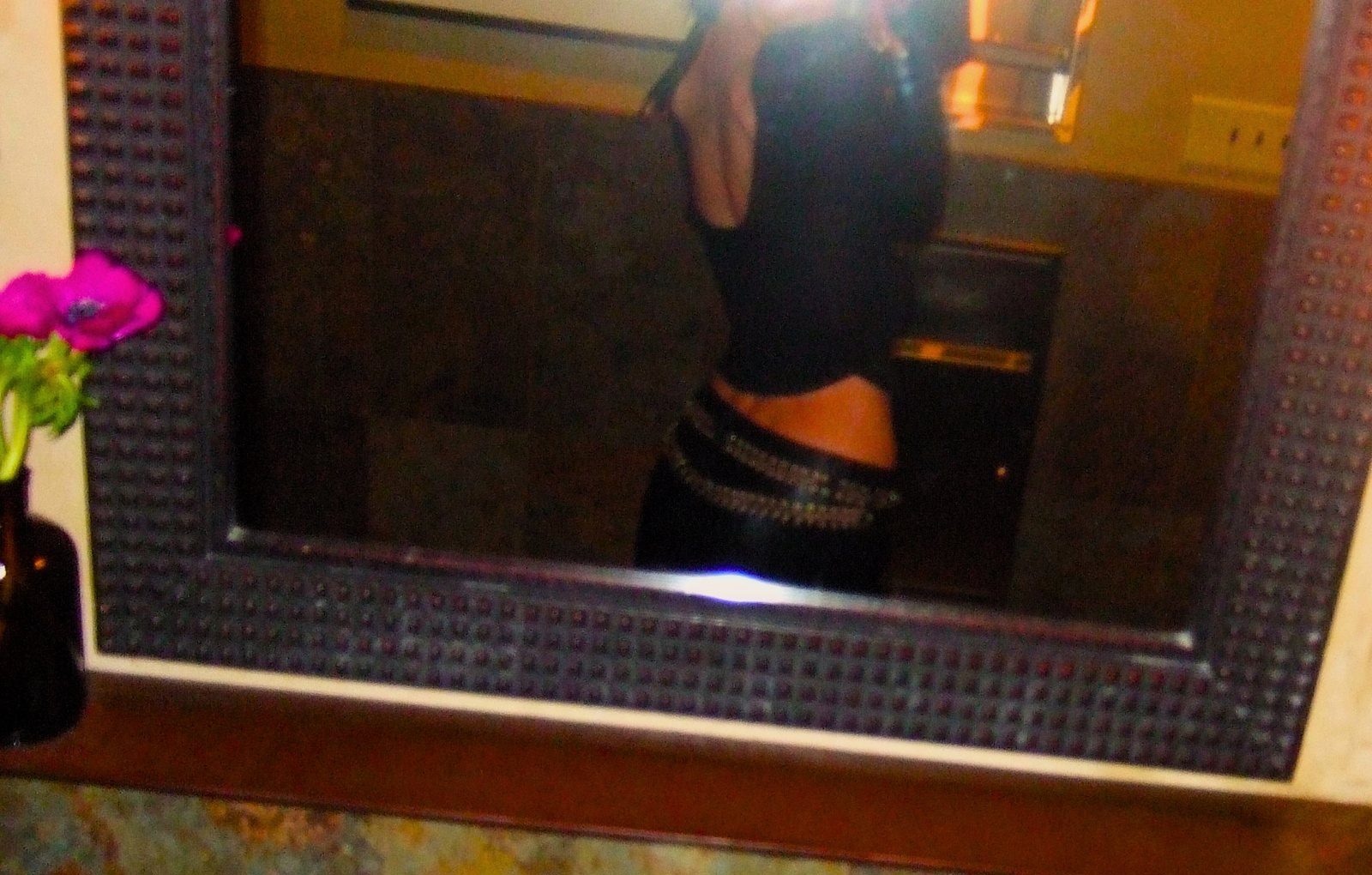 From Kara Hobby’s Wilson Mom summer: mirror selfie with a studded belt beside a pink flower
