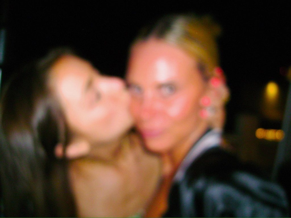 From Kara Hobby’s Wilson Mom summer: friend kissing a woman on the cheek at night