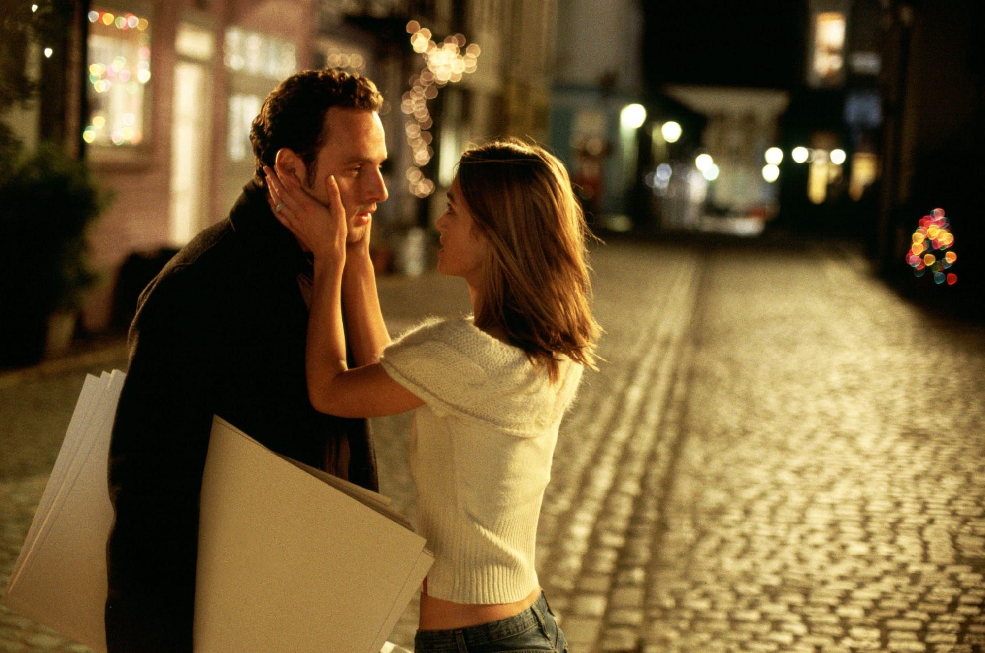 Image of Andrew Lincoln and Keira Knightley in 'Love Actually.' Knightley is holding Lincoln's face as they stand in the street.