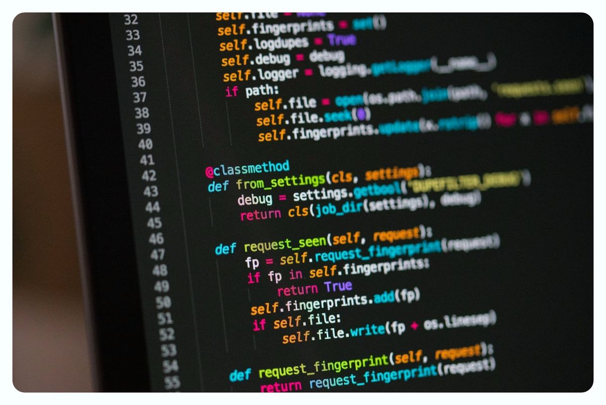 A laptop screen with lines of computer code on a black background.