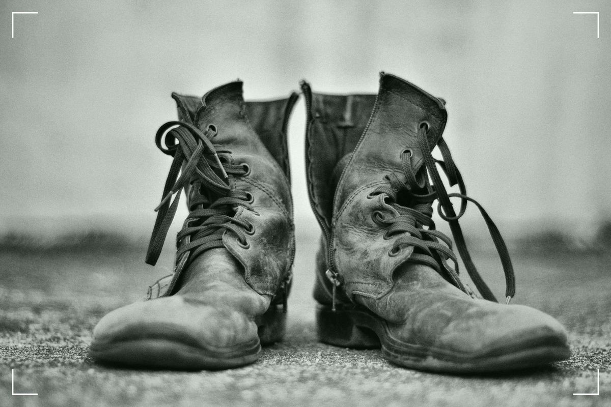 A pair of old fashioned, worn shoes photographed in black & white.