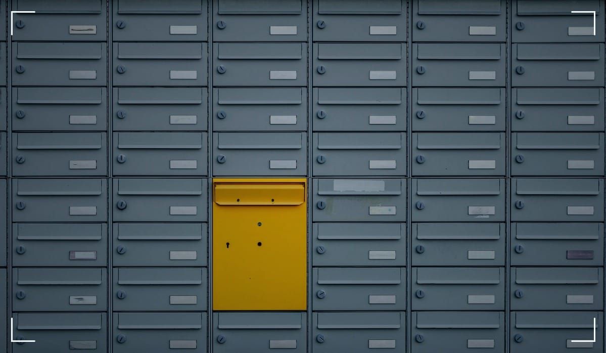 Mailboxes with a yellow one in the middle of the picture.