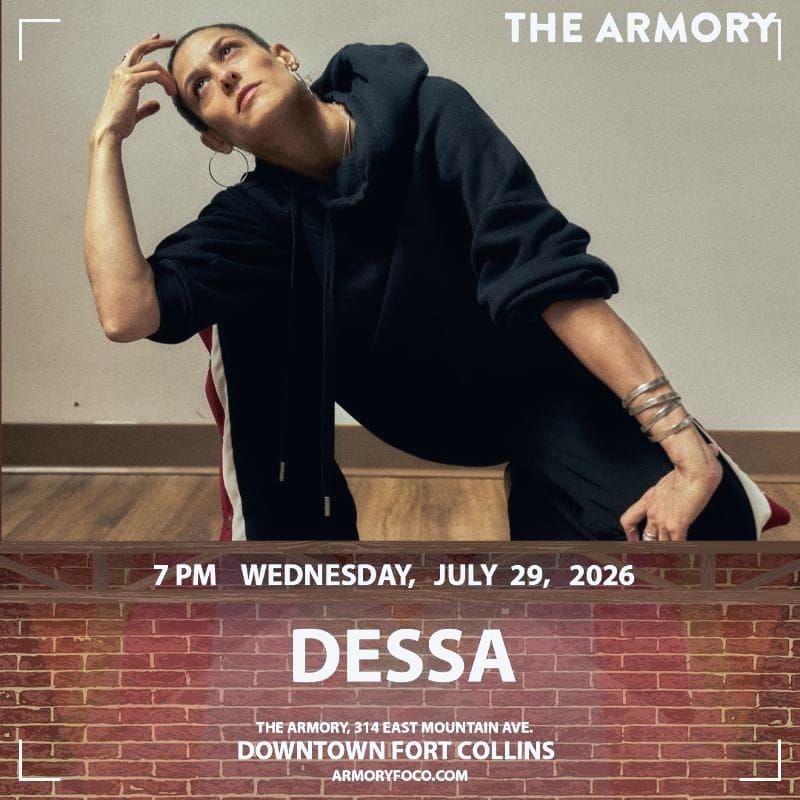 Singer Dessa on top of a brick wall looking at the sky striking a typical hip-hop pose 