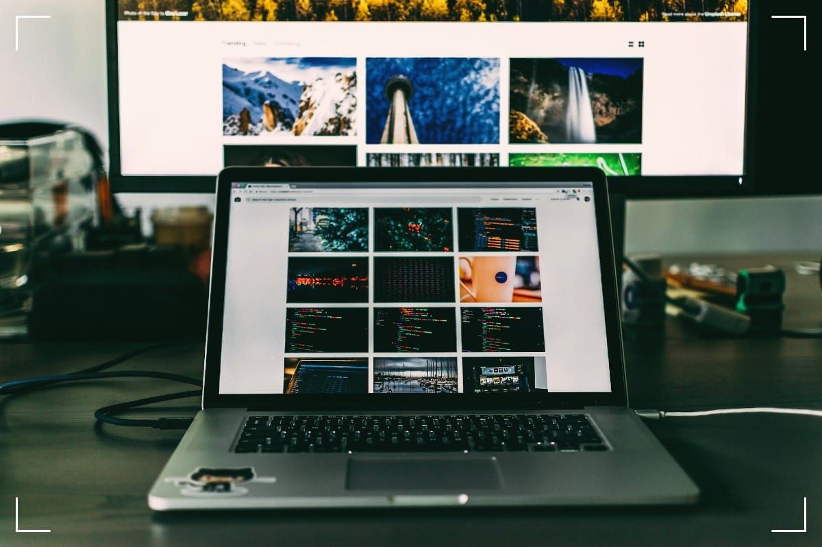 A photographers Macbook laptop with a bigger screen in the background.