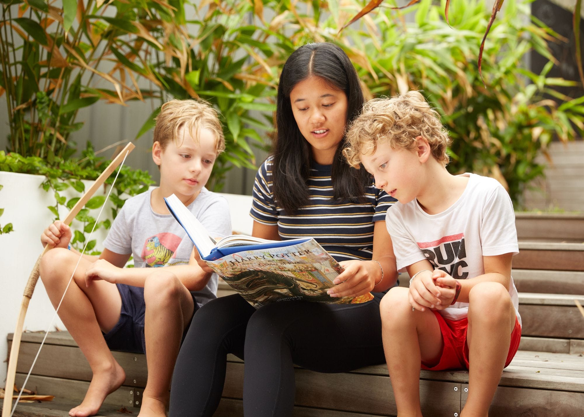 a nanny reading a book to two boys.jpg