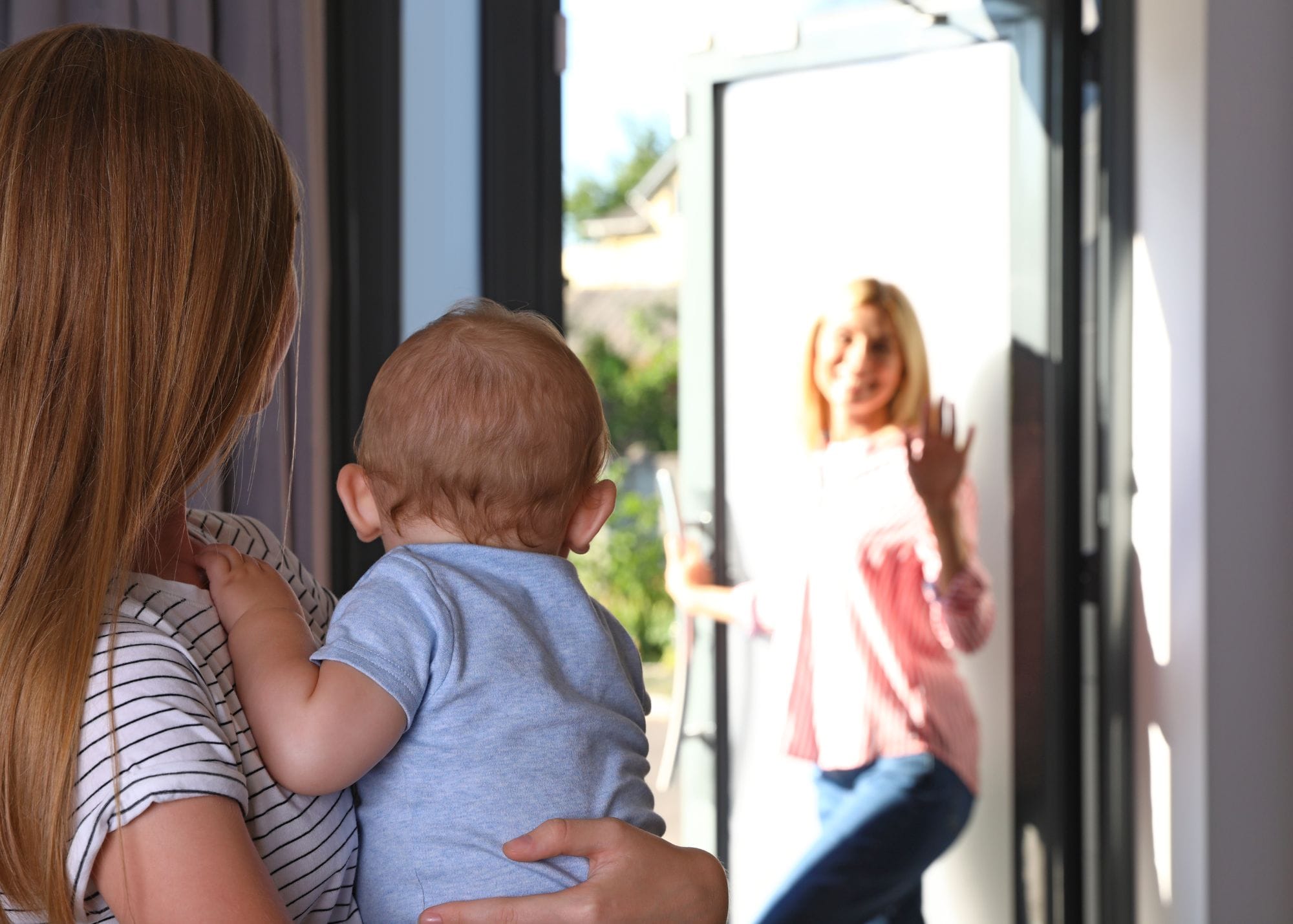 woman holding a baby whilst answering the door.jpg