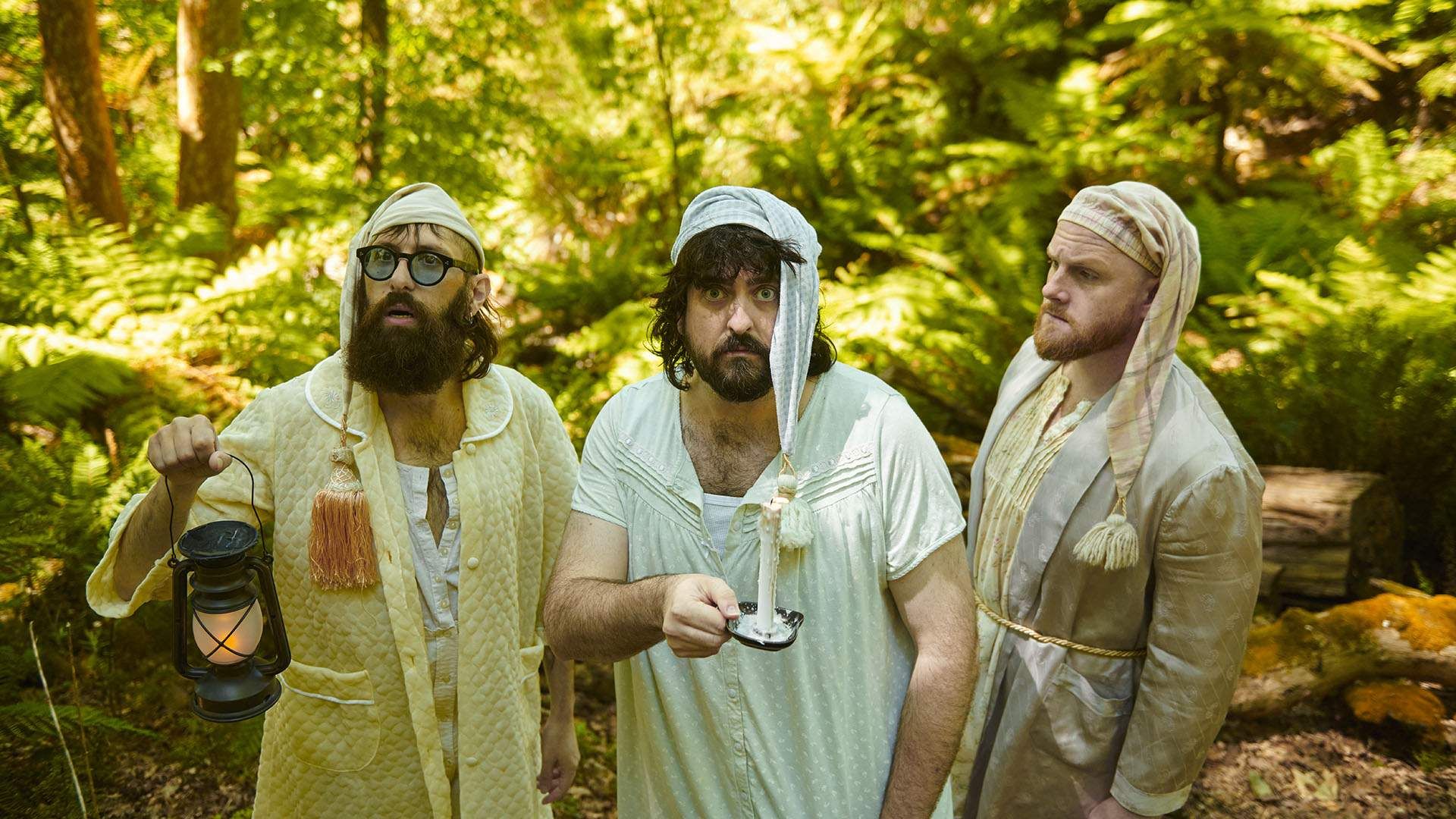Members of the Australian anti-comedy trio Aunty Donna standing outside, wearing nightgowns and caps. 