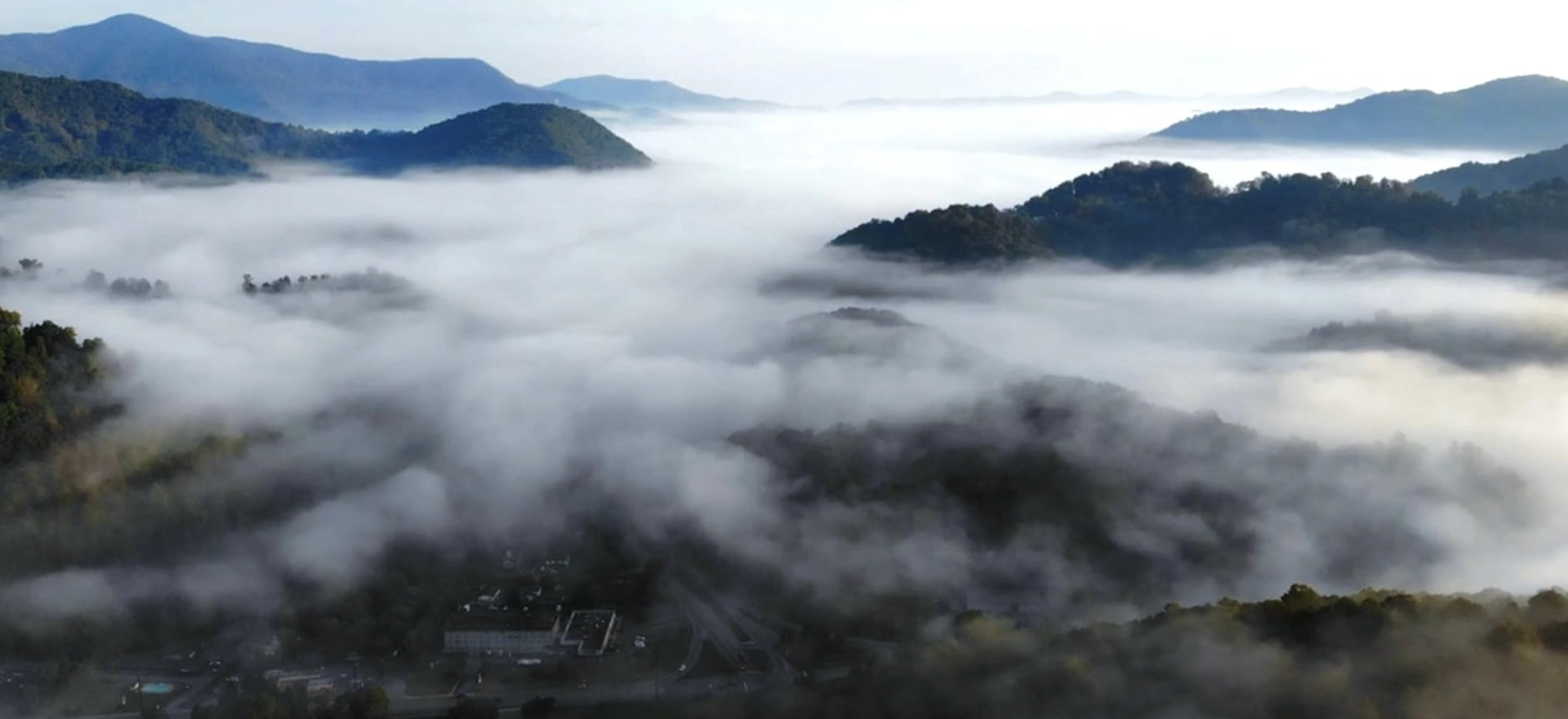 fog swirls through a series of mountain ranges