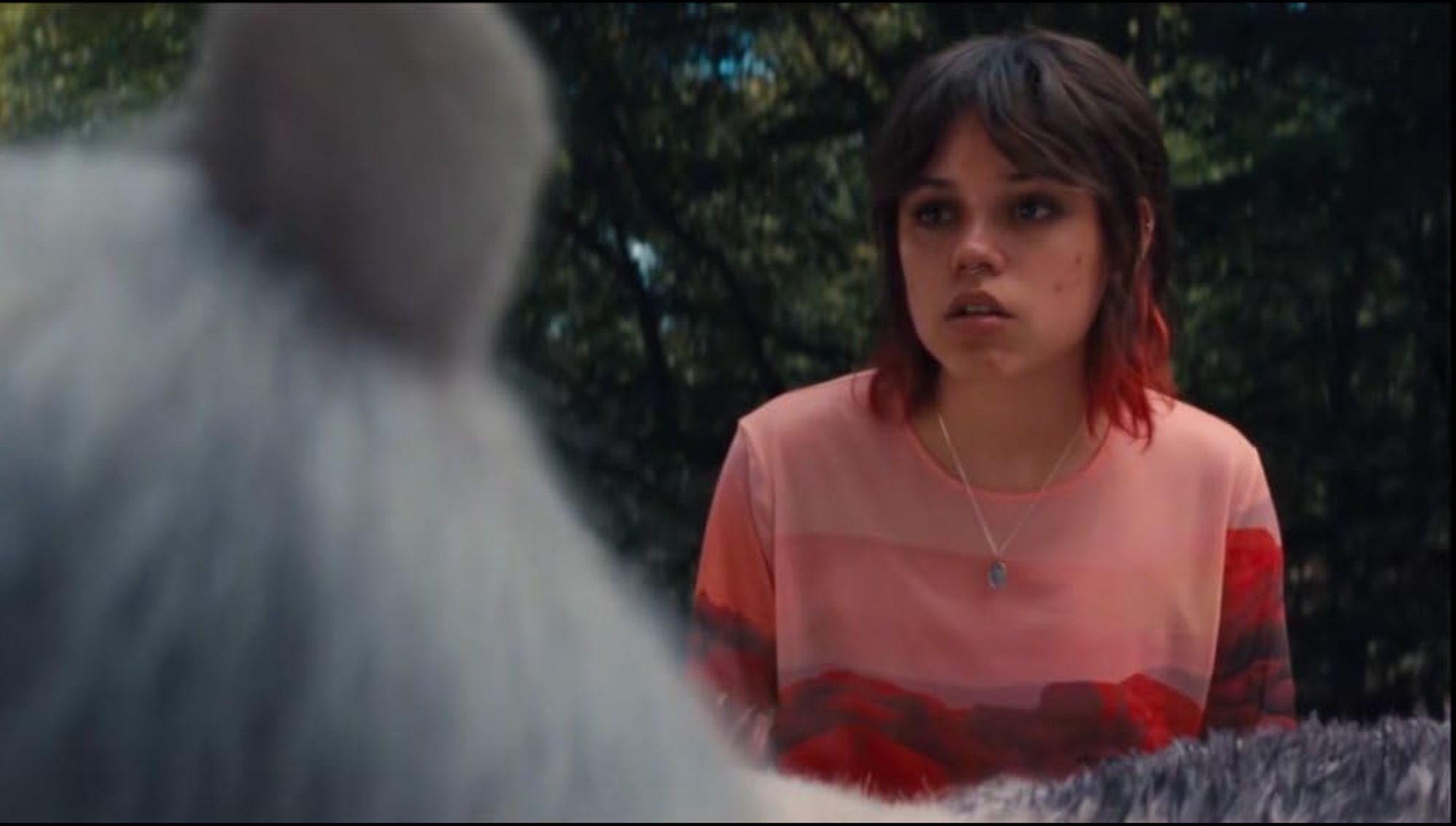 a woman looks in awe at a unicorn, we see only the back of the creatures head and part of its body
