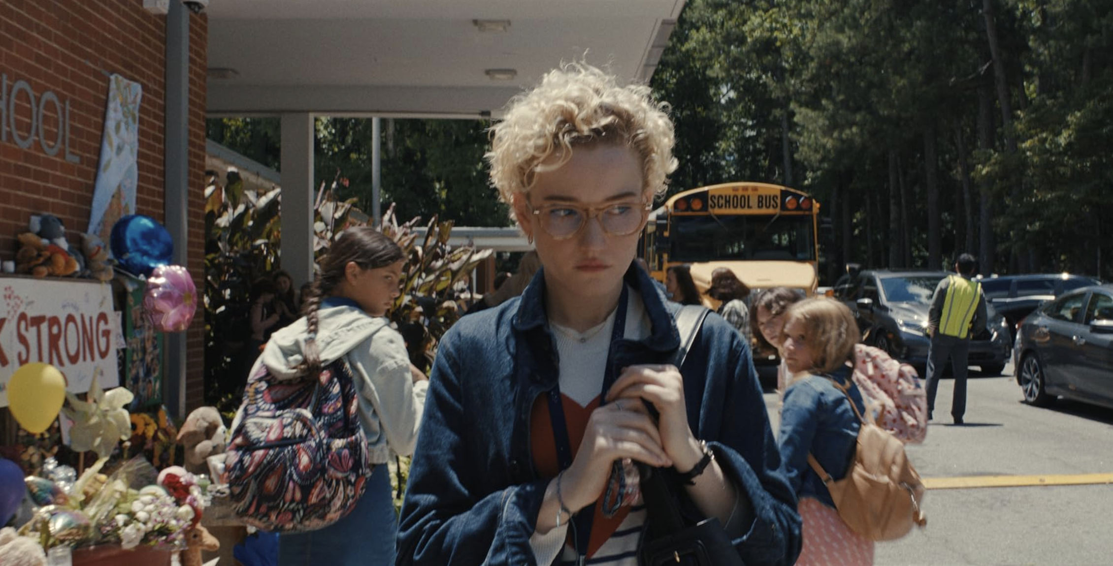 A woman walks past a crowd, while people turn to stare at her.