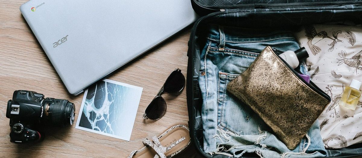 black DSLR camera near sunglasses and bag