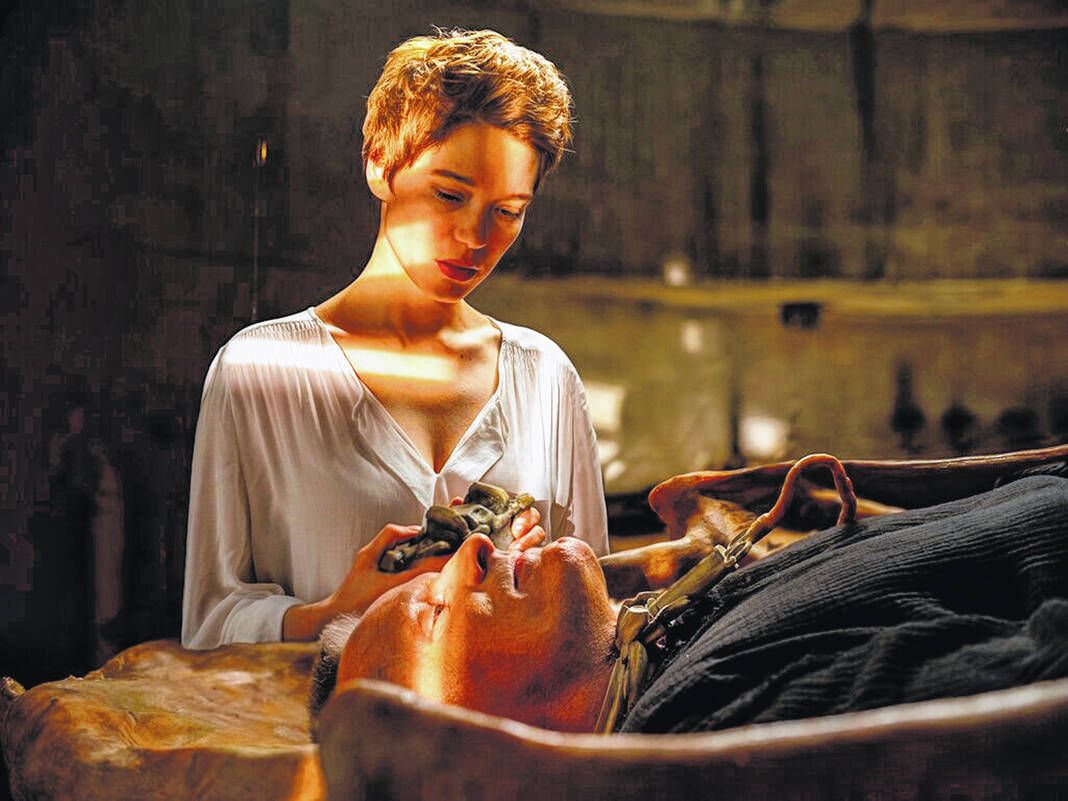 Lea Seydoux gazes worshipfully at a prone Viggo Mortensen in a still from CRIMES OF THE FUTURE.