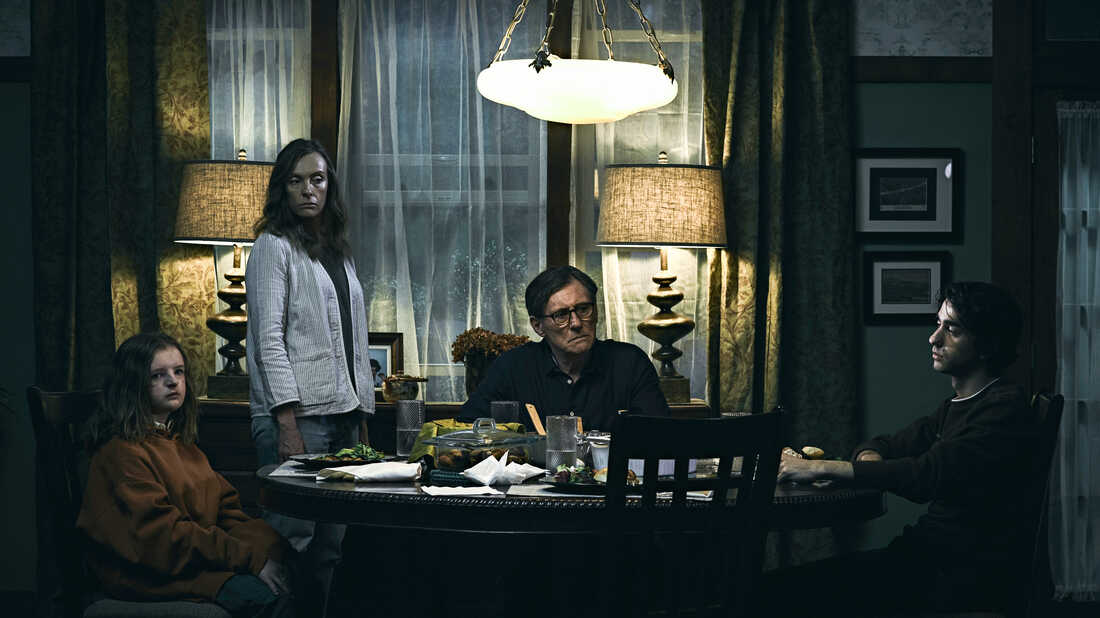 Milly Shapiro, Toni Collette, Gabriel Byrne and Alex Wolff assemble for dinner in a moody publicity still for Ari Aster's HEREDITARY.