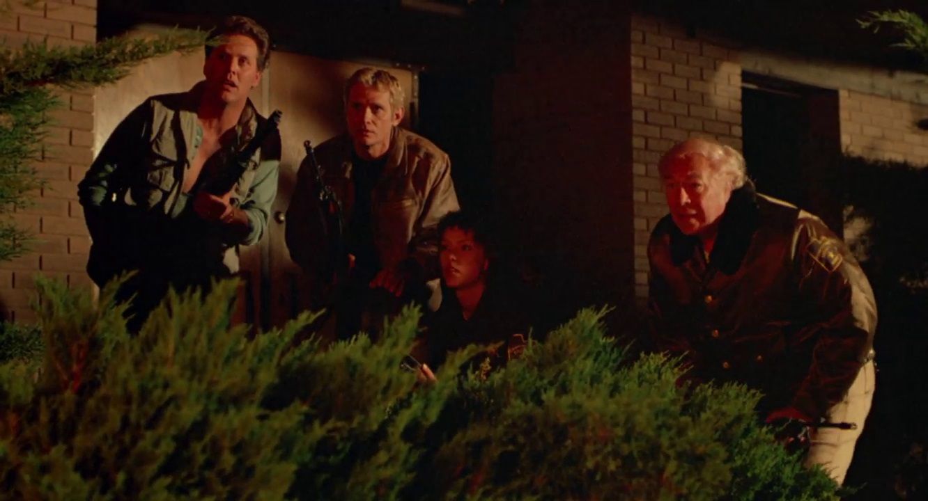 Wings Hauser, Bo Hopkins, Kimberly Ross (crouching) and George Kennedy hide behind a bush in NIGHTMARE AT NOON.