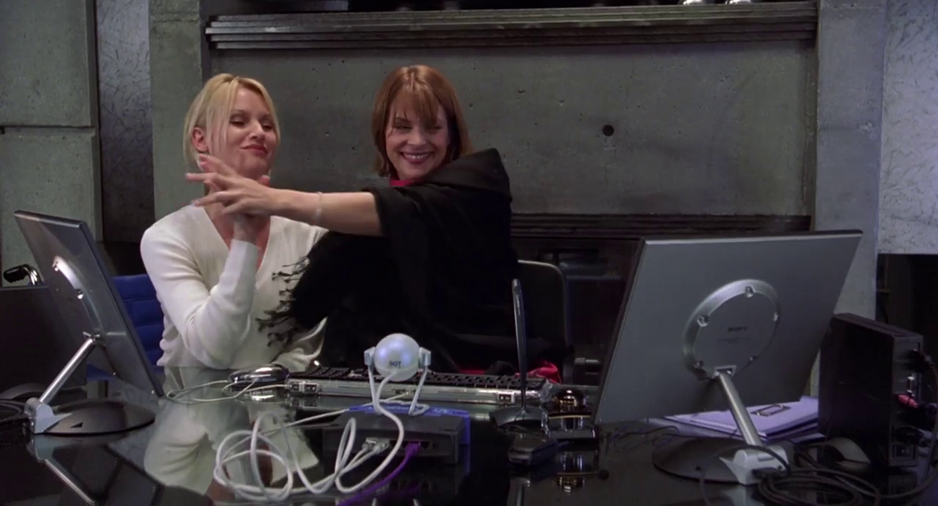 Nicolette Sheridan and Nastassja Kinski high-five in a still from .COM FOR MURDER.