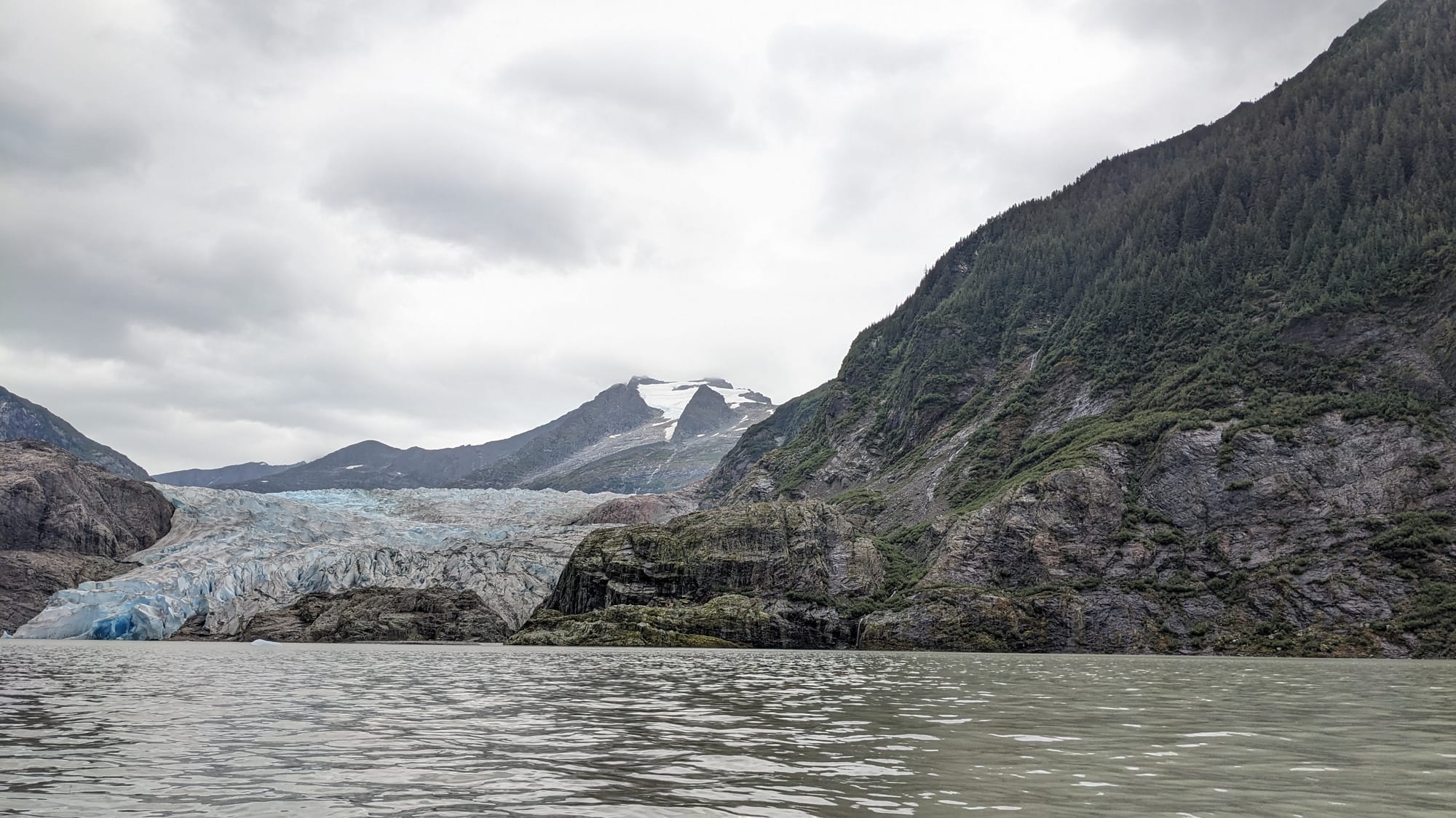 This is a giant blue glacier next to an even bigger green mountain